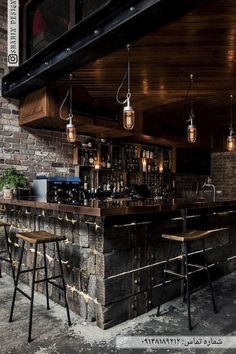 an image of a bar with stools in the middle and lights hanging from the ceiling