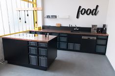 an empty kitchen with black cabinets and counter tops