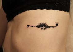 a woman's stomach with a mustache tattoo on it