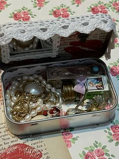 an open tin with jewelry inside on a table