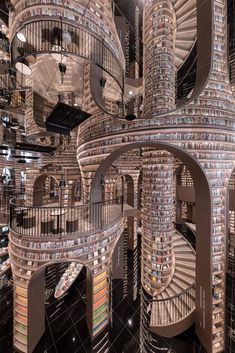 a spiral staircase made out of books in the middle of a room filled with stairs