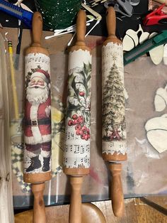 three wooden rolling pins decorated with christmas images