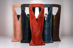 four different colored leather bags with pens in them