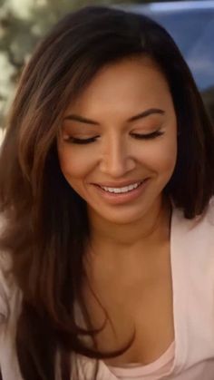 a woman smiling and looking at her cell phone