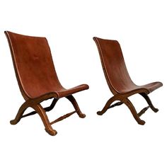 a pair of wooden chairs sitting next to each other on top of a white background