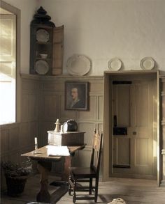 an old fashioned kitchen with wooden floors and walls, along with pictures on the wall