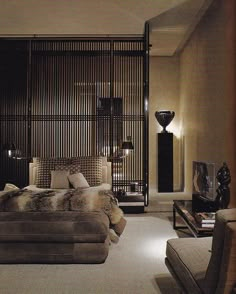 a large bed sitting in the middle of a living room next to a tall wooden screen