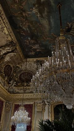 a chandelier hangs from the ceiling in an ornate room