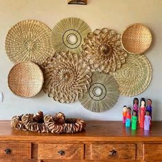 a wooden dresser topped with lots of baskets and knick knacks on top of it