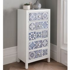 a white cabinet with blue and white tiles on it