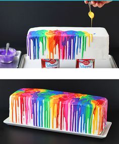 the cake is covered in rainbow icing and has two cans of ice cream on it