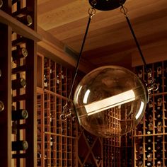 a glass ball hanging from the ceiling in a wine cellar