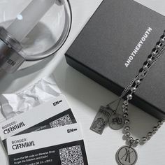 a box with two tags on it next to a necklace