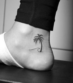 a small palm tree on the ankle tattoo is shown in this black and white photo