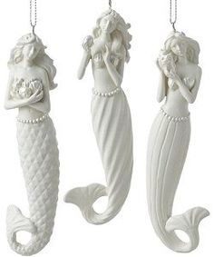 three ceramic mermaid ornaments hanging from chains