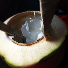 an open coconut with a spoon in it