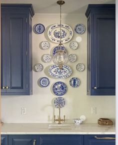 a kitchen with blue cabinets and plates on the wall