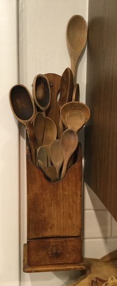 wooden spoons are in a holder on the wall