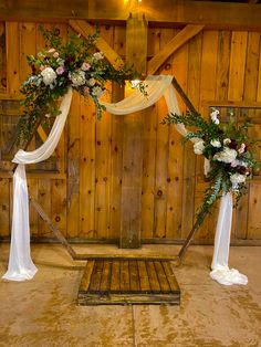 the wedding arch is decorated with white and pink flowers