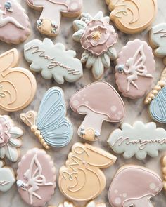 decorated cookies are arranged in the shape of flowers, mushrooms, and other things on a marble surface