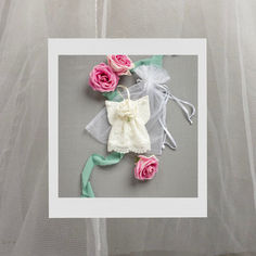 some pink roses and white organine bags on a gray surface with netting around them