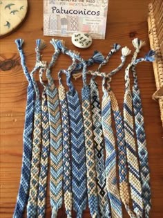 several pieces of blue and white knitted fabric on a wooden table next to a button