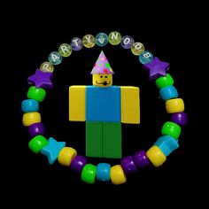 a lego man with a party hat and beads around it's neck on a black background