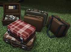 four suitcases sitting in the grass with one open and another closed, all on top of each other