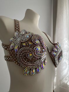 a white mannequin wearing a bra with lots of jewels on it's chest