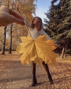 a woman is holding onto a large leaf