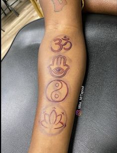 a person with a tattoo on their arm that has three symbols in different colors and shapes