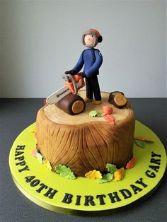 a birthday cake with a man on top of a tree stump holding a chainsaw