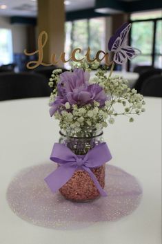 a vase filled with purple flowers and baby's breath on top of a table