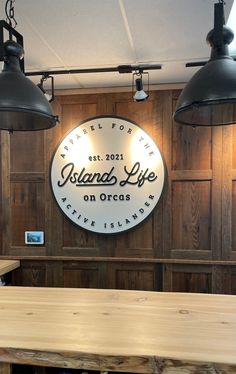 the interior of a restaurant with wood paneling and metal lights hanging from the ceiling