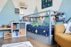 a child's bedroom with blue walls and furniture