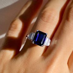 a woman's hand with a blue and white ring on top of her finger