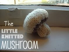 the little knitted mushroom is sitting in front of a window sill with text overlay that reads, the little knitted mushroom