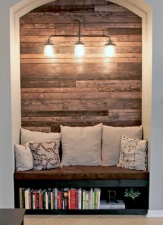 a room with a couch and bookshelf next to a wall made out of wood planks