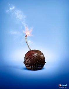 a chocolate cupcake with a sparkler sticking out of it's top on a blue background