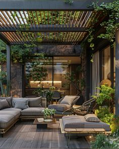 an outdoor living area with couches, tables and plants on the decking floor