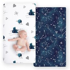 a baby laying on top of a blanket next to an open book with stars and planets