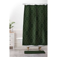 a bathroom with a green shower curtain and rug