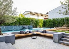 an outdoor patio with seating and water feature in the back yard, next to a swimming pool