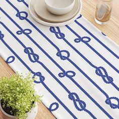 a place mat with blue rope and knots on it, next to a potted plant