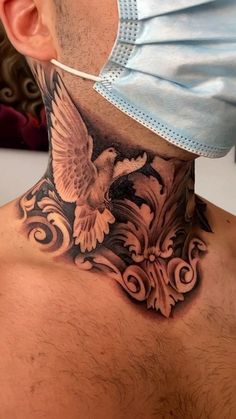 a man wearing a surgical mask and neck tattoo with an eagle on the back of his neck