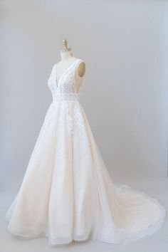 a wedding dress on display in a white room