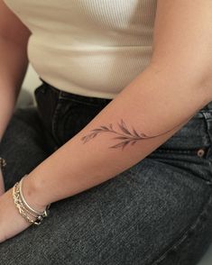 a woman's arm with a small tattoo on it