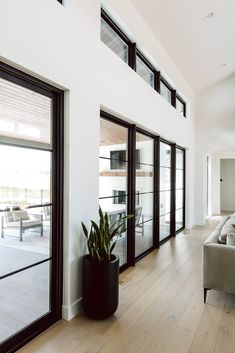 a living room filled with furniture next to sliding glass doors on the side of a wall