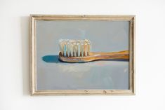 an oil painting of a toothbrush on a white wall next to a wooden frame