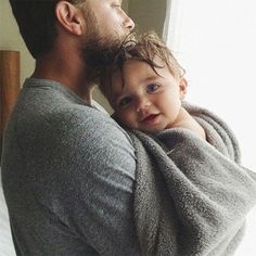 a man holding a baby wrapped in a blanket